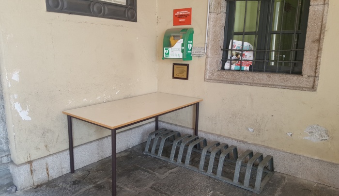 Il defibrillatore “ingombrato” da un tavolo e dalla rastrelliera delle bici